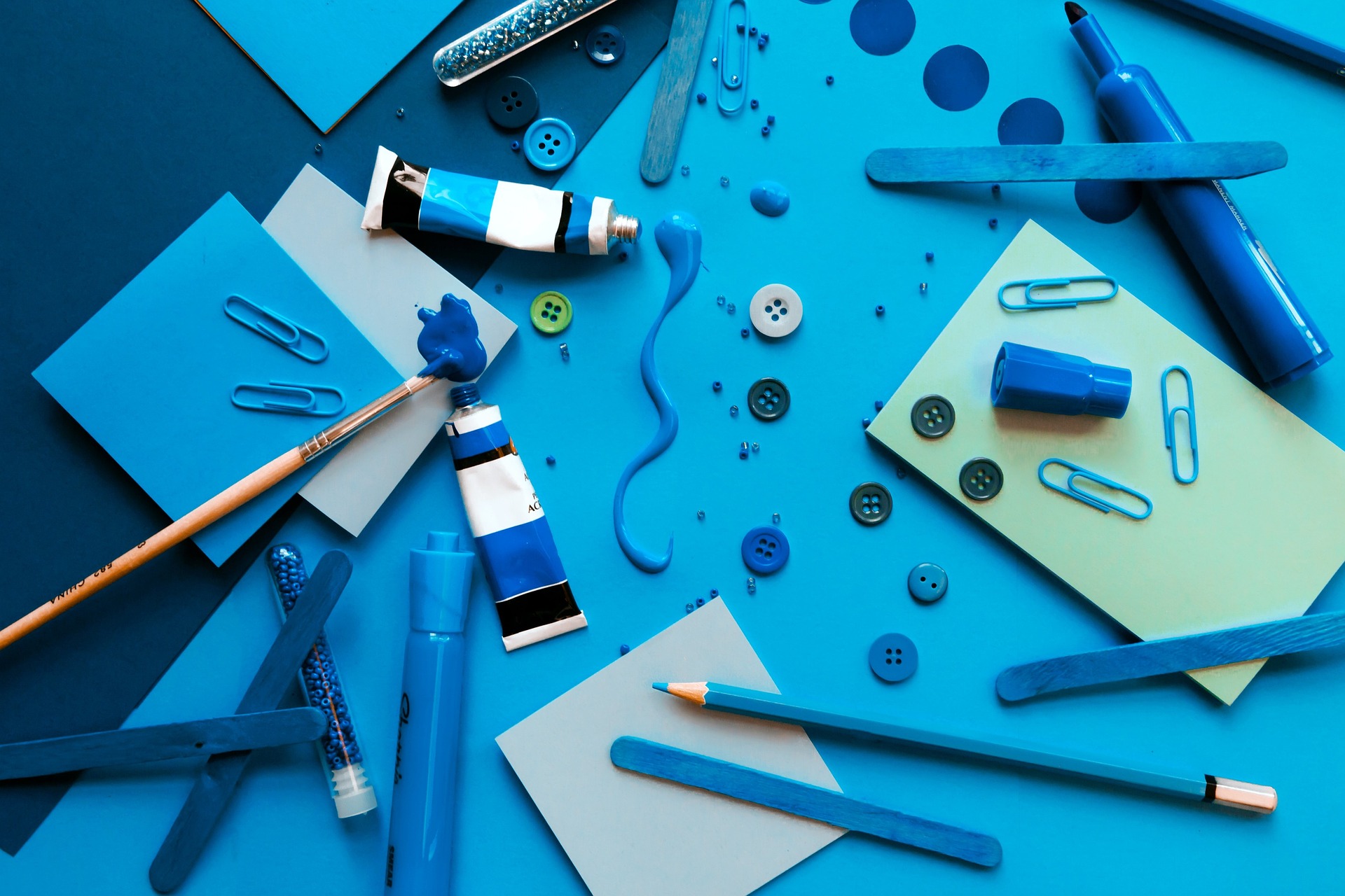 Blue papers, buttons, markers, paint, beads